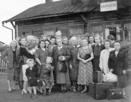 Kirovi oblasti Vahruševo raudteejaama ees alevi esimest asumiselt vabastatud eestlast 1954 kodumaale saatmas. Pr. Aurelie Üksti (keskel käekotiga) vabastamisega võimaldati temal hooldada lähedast sugulast Enn Soosaart Eestis, kes liiklusavarii tõttu oli invaliidistunud. Enamus 1941. aasta juuniküüditatutest vabastati asumiselt alles 1956–1958.  Foto U. Tomassoni kogust